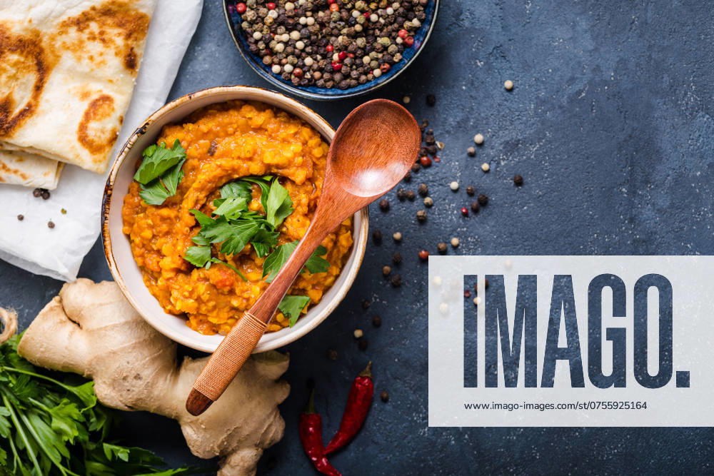 Traditionelle indische Linsen Dal, Naan-Butterbrot. Platz für Text. Indische Dhal würzigen Curry in Schüssel, Gewürze, Kräuter, rustikalen Beton Hintergrund. Ansicht von oben. Indisches Essen. Authentisches indisches Gericht. Platz zum Kopieren Traditional Indian lentils Dal, naan butter bread. Space for text. Indian Dhal spicy curry in bowl, spices, herbs, rustic concrete background. Top view. Indian food. Authentic Indian dish. Copy space
