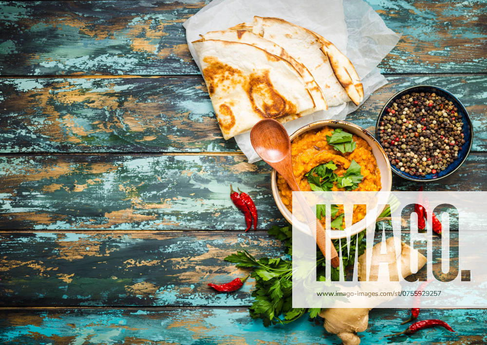Traditionelle indische Linsen Dal, Naan-Butterbrot. Platz für Text. Indische Dhal würzigen Curry in Schüssel, Gewürze, Kräuter, rustikalen hölzernen Hintergrund. Ansicht von oben. Indisches Essen. Authentisches indisches Gericht. Platz zum Kopieren Traditional Indian lentils Dal, naan butter bread. Space for text. Indian Dhal spicy curry in bowl, spices, herbs, rustic wooden background. Top view. Indian food. Authentic Indian dish. Copy space