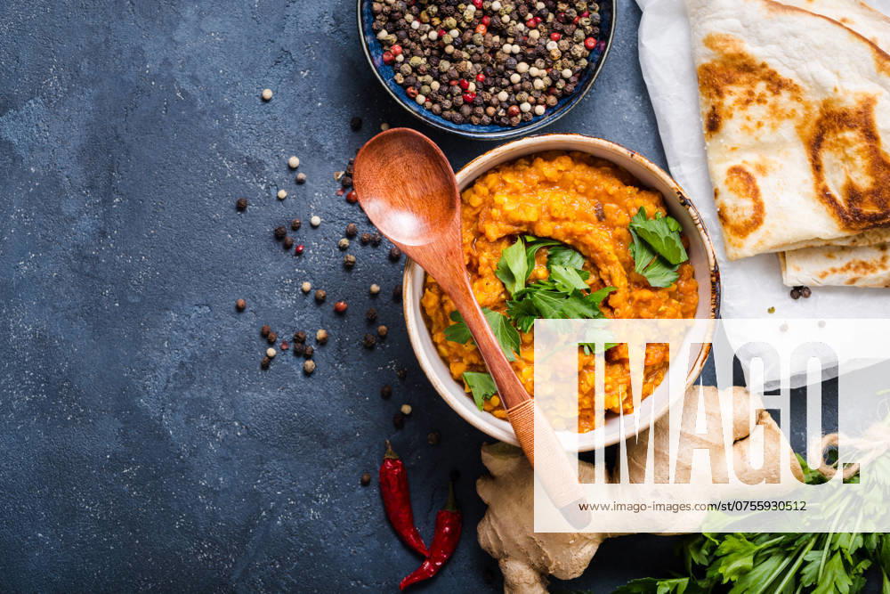 Traditionelle indische Linsen Dal, Naan-Butterbrot. Platz für Text. Indische Dhal würzigen Curry in Schüssel, Gewürze, Kräuter, rustikalen Beton Hintergrund. Ansicht von oben. Indisches Essen. Authentisches indisches Gericht. Platz zum Kopieren Traditional Indian lentils Dal, naan butter bread. Space for text. Indian Dhal spicy curry in bowl, spices, herbs, rustic concrete background. Top view. Indian food. Authentic Indian dish. Copy space