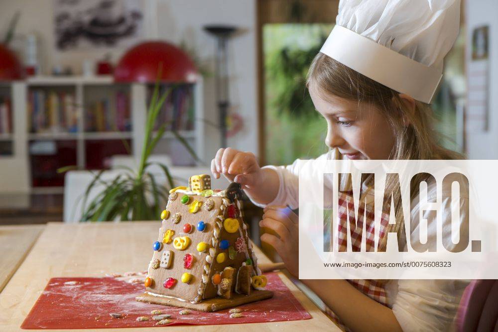 Girl garnishing gingerbread house model released Symbolfoto property released SARF03091