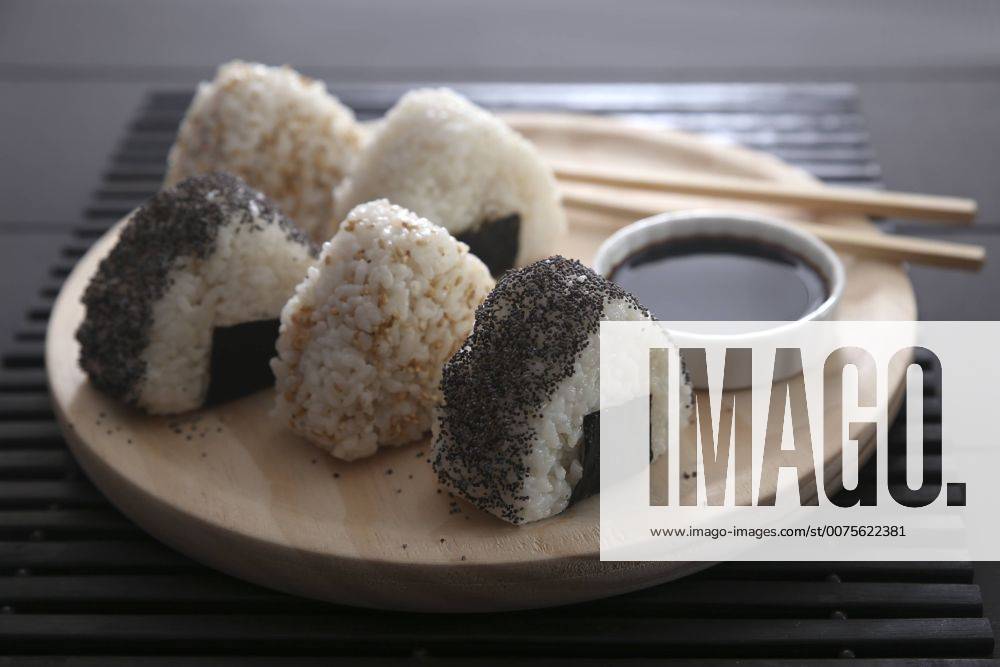 IMAGO Creative: Food, Mohn Onigiris, bowl with soy sauce and chopsticks on wooden plate RTBF00531