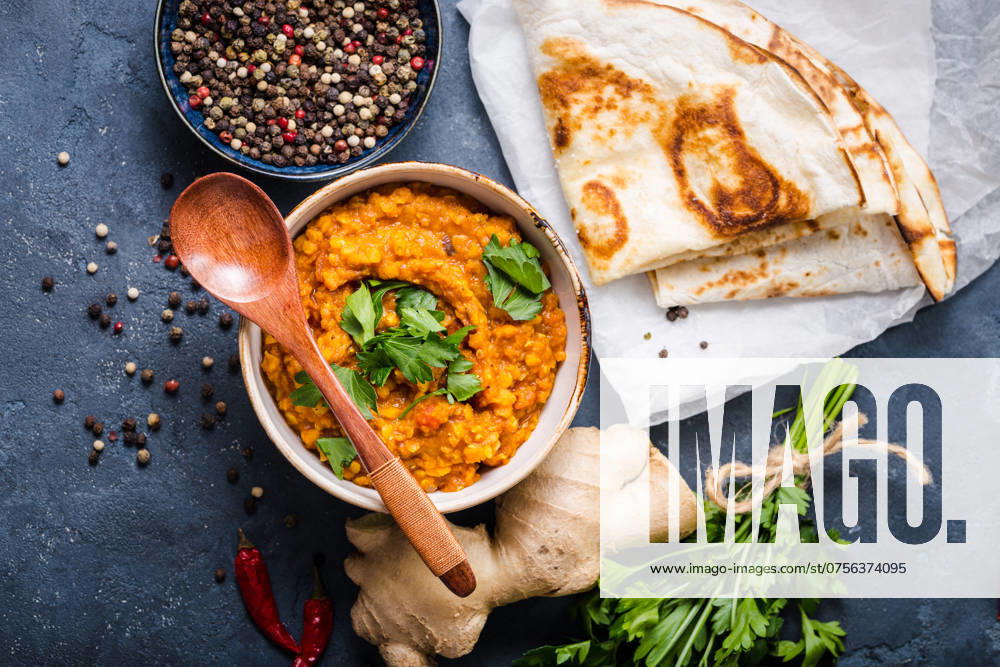 Traditionelle indische Linsen Dal, Naan-Butterbrot. Platz für Text. Indische Dhal würzigen Curry in Schüssel, Gewürze, Kräuter, rustikalen Beton Hintergrund. Ansicht von oben. Indisches Essen. Authentisches indisches Gericht. Platz zum Kopieren Traditional Indian lentils Dal, naan butter bread. Space for text. Indian Dhal spicy curry in bowl, spices, herbs, rustic concrete background. Top view. Indian food. Authentic Indian dish. Copy space