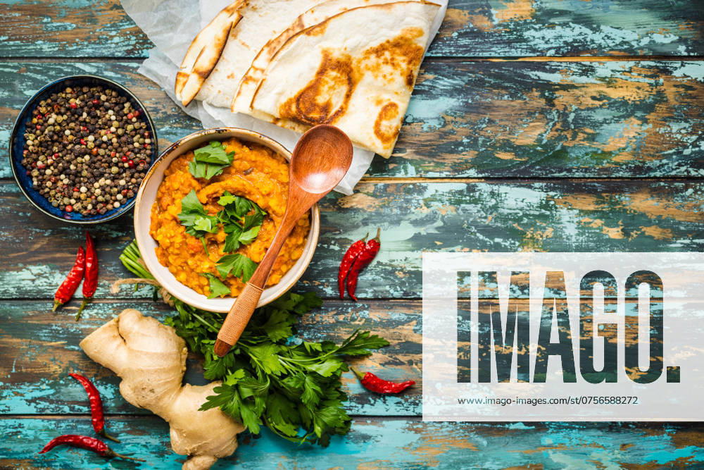Traditionelle indische Linsen Dal, Naan-Butterbrot. Platz für Text. Indische Dhal würzigen Curry in Schüssel, Gewürze, Kräuter, rustikalen hölzernen Hintergrund. Ansicht von oben. Indisches Essen. Authentisches indisches Gericht. Platz zum Kopieren Traditional Indian lentils Dal, naan butter bread. Space for text. Indian Dhal spicy curry in bowl, spices, herbs, rustic wooden background. Top view. Indian food. Authentic Indian dish. Copy space