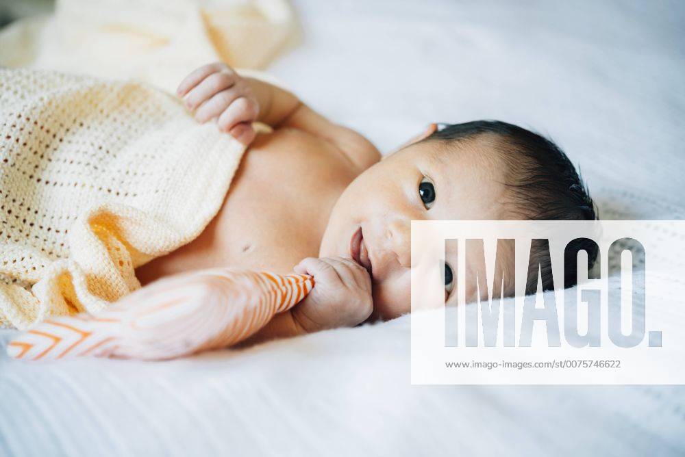 Portrait of newborn lying on bed model released Symbolfoto GEMF01304
