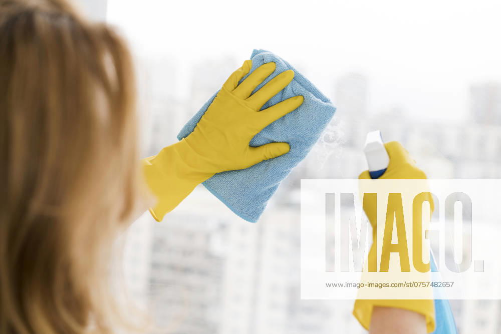 Frau putzt Fenster mit Lappen woman cleaning window with rag