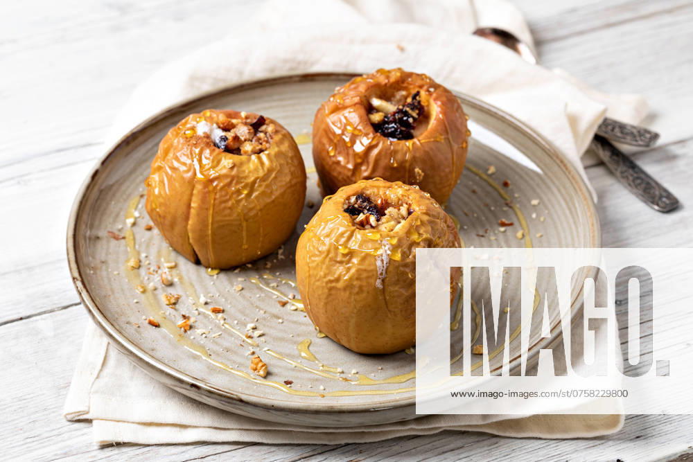 Süßer Bratapfel mit Honig, Nüssen, Cranberries und Zimt Sweet baked Apple with honey, nuts, cranberries and cinnamon
