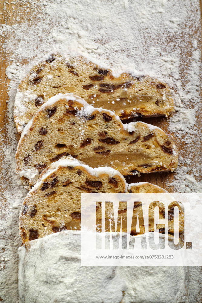 Drei Scheiben Weihnachtsstollen auf einem Holzbrett Three slices of Christmas stollen on a wooden board
