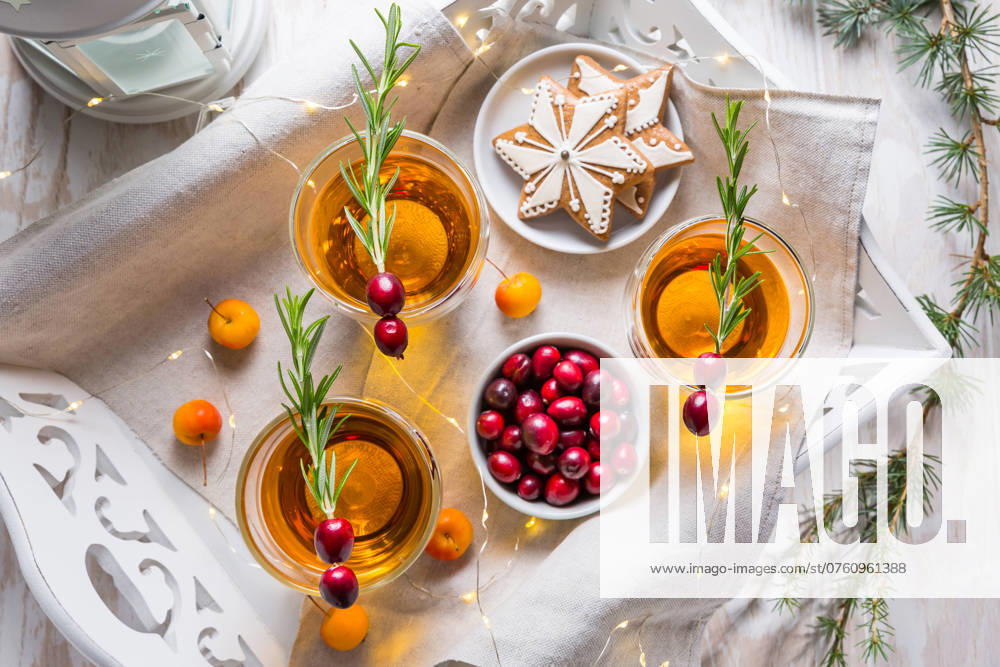 Weihnachtlicher Apfelcidre Cocktail mit Preiselbeeren, Rosmarin und Lebkuchengebäck. Glühapfelwein für Weihnachten Christmas apple cider cocktail with cranberries, rosemary and gingerbread cookies. Mulled apple wine for Christmas