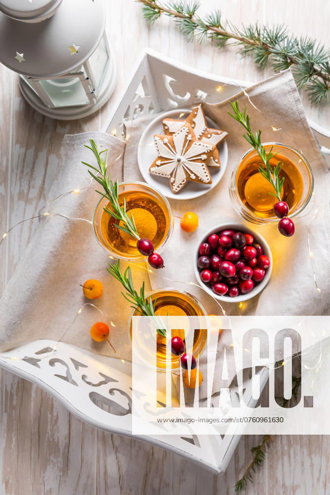 Weihnachtlicher Apfelcidre Cocktail mit Preiselbeeren, Rosmarin und Lebkuchengebäck. Glühapfelwein für Weihnachten Christmas apple cider cocktail with cranberries, rosemary and gingerbread cookies. Mulled apple wine for Christmas