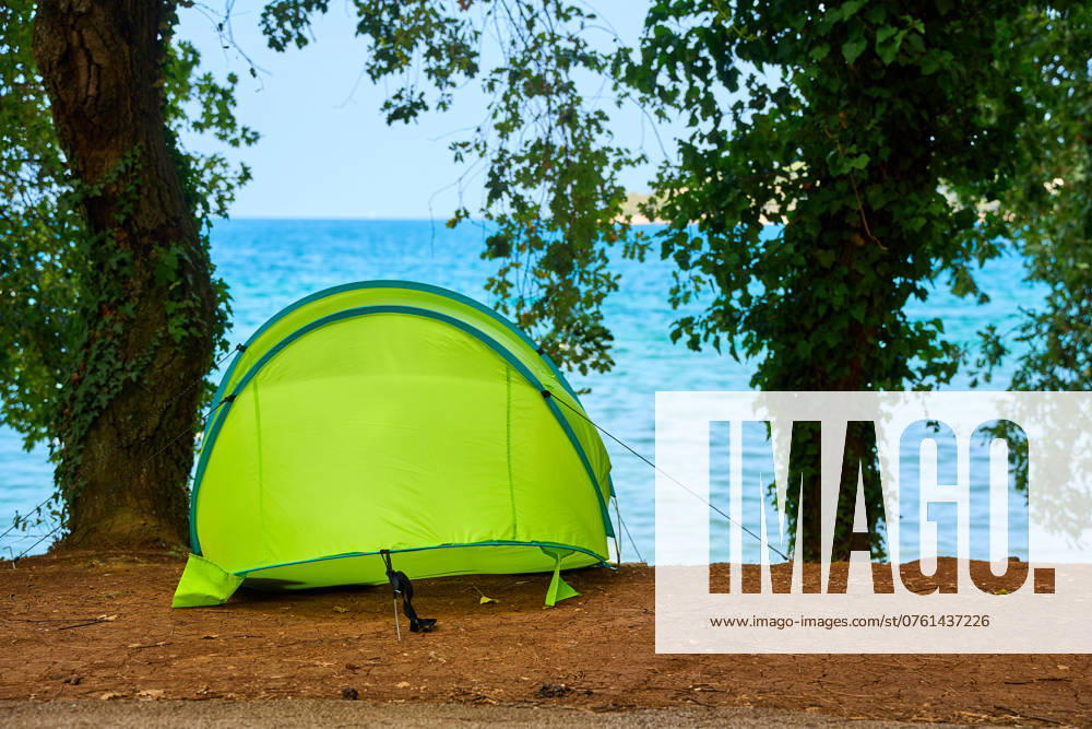 A green tent stands on a campsite right by the sea in Porec, Croatia, offering an idyllic outdoor experience in nature