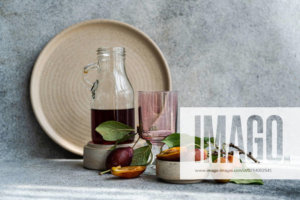 IMAGO Creative, Jahreszeit Sommer, Food, Pflaume Ripe plums and liqueur on concrete table Tbilisi, Tbilisi, Georgia R_LSQHTY2409047F-1532995-01