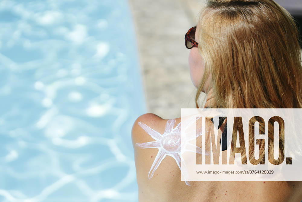 Woman with sun shaped lotion on back at poolside model released, Symbolfoto, SIF01160