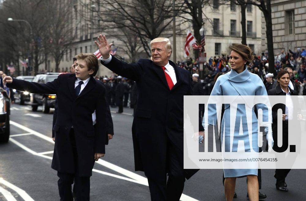 President Donald Trump waves as he walks with first lady Melania Trump and their son Barron, left, during the inauguration parade on Pennsylvania Avenue in Washington, DC on January 20, 2017. Trump became the 45th President of the United States. Pool photo by Evan Vucci WAX201701202116 EVANxVUCCI
