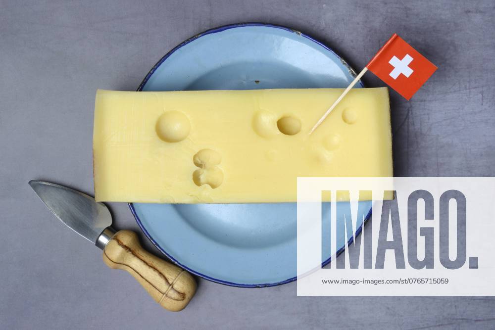 Ein Stück Schweizer Emmentaler Käse auf Teller und Schweizer Fahne A piece of Swiss Emmental cheese on a plate and the Swiss flag