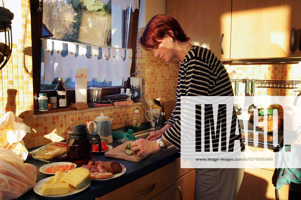 Zingst, Mecklenburg-Vorpommern, DEU - Eine Frau macht das Fruehstueck. (Mensch, Frau, Gesellschaft, Lebenswelt, Lebenswelten, Alltag, Familie, Mutter, Ernaehrung, Erwachsene, Erwachsener, Essen, Hausfrau, Hunger, hungrig, Kochen, Fruehstueck, Kaese, Wurst, Gurken, Gurke, schneiden, Kaffee, Kaffeekanne, Anrichte, Kueche, Kuechenszene, Speise, Speisen, Zubereitung, zubereiten, Innenaufnahme, Nahrung, Oeko, Oekologisch, Bio, Licht, Lichtstimmung, Kuechenimpressionen, Kuechenimpression, Kuechenutensilien, Essen und Trinken, Abendbrot, digital, QF, Küchenimpressionen, Küchenimpression, Küchenutensilien, Ernährung, Frühstück, Käse, Küche, Küchenszene, Öko, Ökologisch) 00S051119D001.JPG MODEL RELEASE: NO MR:N