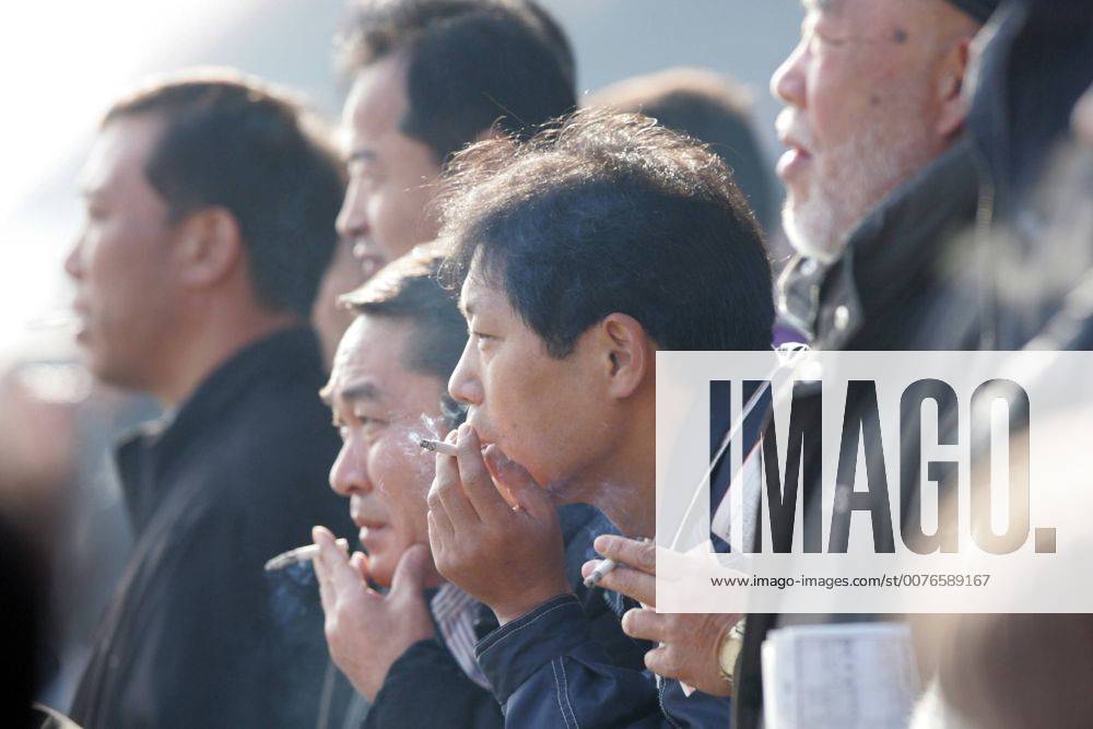 Seoul, KOR, KOREA - Koreanische Maenner rauchen Zigaretten. (Seoul, Korea, Suedkorea, Asien, aussen, Aussenaufnahme, Gesellschaft, Lebenswelt, Lebenswelten, Freizeit, Mensch, Menschen, abhaengig, Abhaengigkeit, Droge, Genussmittel, Gesundheit, gesundheitsgefaehrdend, gesundheitsschaedlich, Gift, giftig, krebsausloesend, krebserregend, Laster, Mann, Nikotin, paffen, Portraet, Portrait, Qualm, qualmen, qualmend, quarzen, Rauch, rauchen, rauchend, Raucher, Schadstoff, schaedlich, Sucht, Suchtbefriedigung, Suchtmittel, suechtig, Symbol, Symbolik, symbolisch, Tabak, Tabakindustrie, Tabaksteuer, Tabakwaren, Wirtschaft, Zigarette, Seitenansicht, 40-50-jaehrig, 40-50 Jahre, Gruppe, koreanisch, Koreaner, Einheimische, Maenner, QF, Südkorea, abhängig, Abhängigkeit, gesundheitsgefährdend, gesundheitsschädlich, krebsauslösend, Porträt, schädlich, süchtig, 40-50-jährig, Männer) 00S061216D MR:N