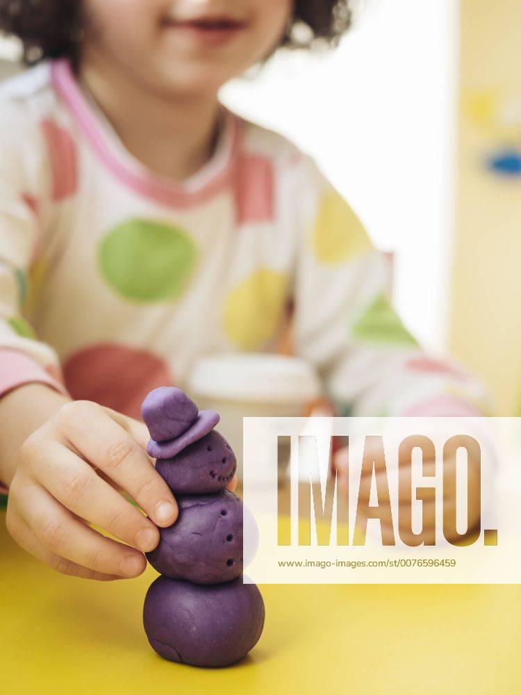 Girl making snowman out of modelling clay model released Symbolfoto property released KRPF02095