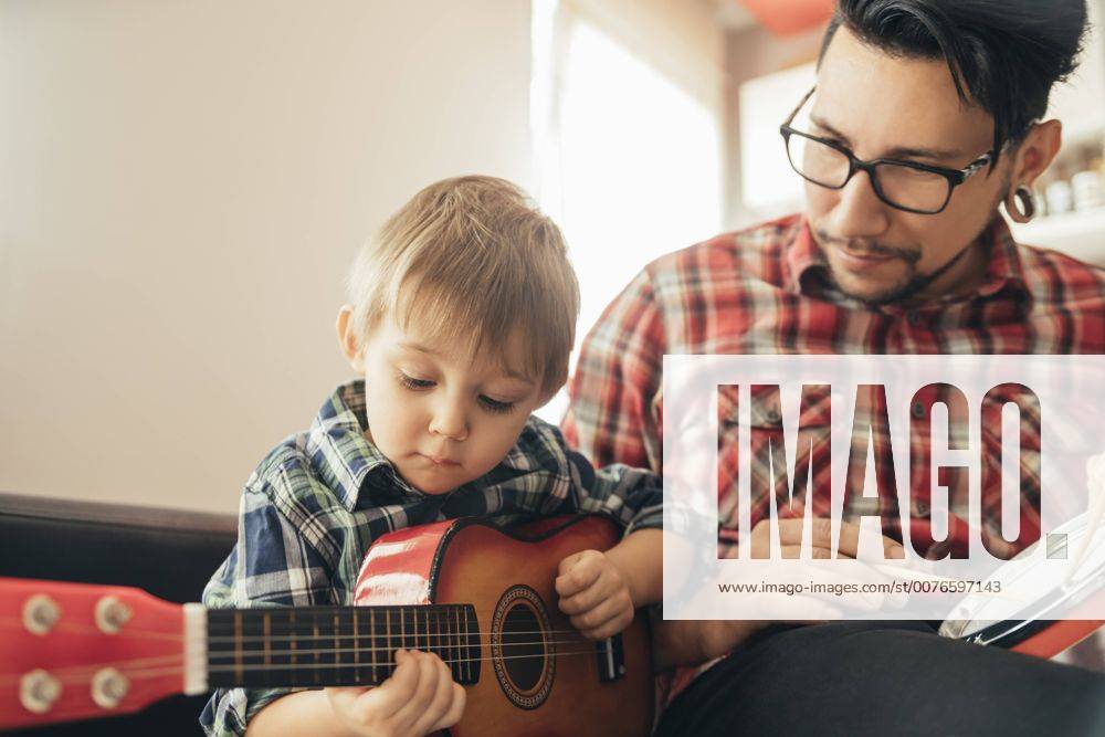 IMAGO Creative: Bildung, Musikerziehung IMAGO Creative: NGO, Ausbildung für Kinder Father and son playing toy musical instruments model released Symbolfoto property released ZEDF00480