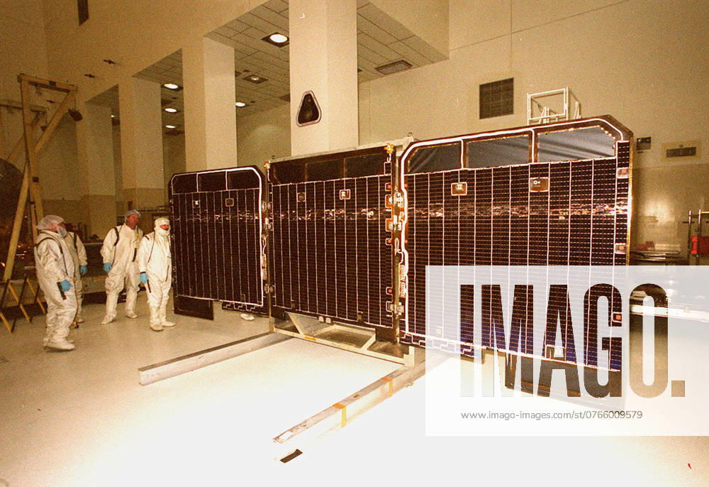 Workers in the Spacecraft Assembly and Encapsulation Facility -2 make a visual check of the front side of the opened solar array panels from the 2001 Mars Odyssey Orbiter. The Mars Odyssey carries three science instruments the Thermal Emission Imaging System (THEMIS), the Gamma Ray Spectrometer (GRS), and the Mars Radiation Environment Experiment (MARIE). THEMIS will map the mineralogy and morphology of the Martian surface using a high-resolution camera and a thermal infrared imaging spectrometer. The GRS will achieve global mapping of the elemental composition of the surface and determine the abundance of hydrogen in the shallow subsurface. The GRS is a rebuild of the instrument lost with the Mars Observer mission. The MARIE will charact