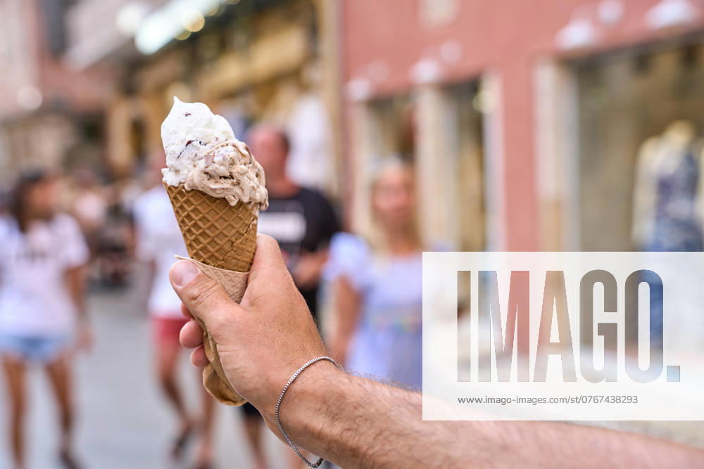 A hand holds an ice cream in a waffle