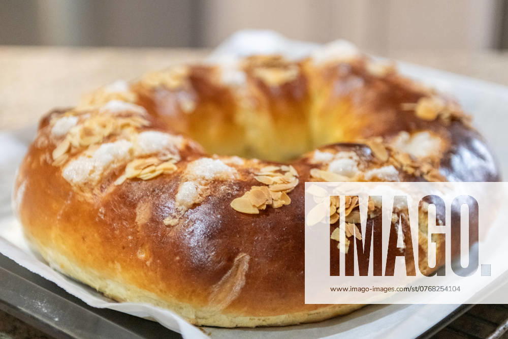 Freshly baked traditional Three Kings Cake, topped with almond slices and sugar, presented on a kitchen counter, symbolizing Epiphany Model Released NataliaPenado_ID24303_704339_031