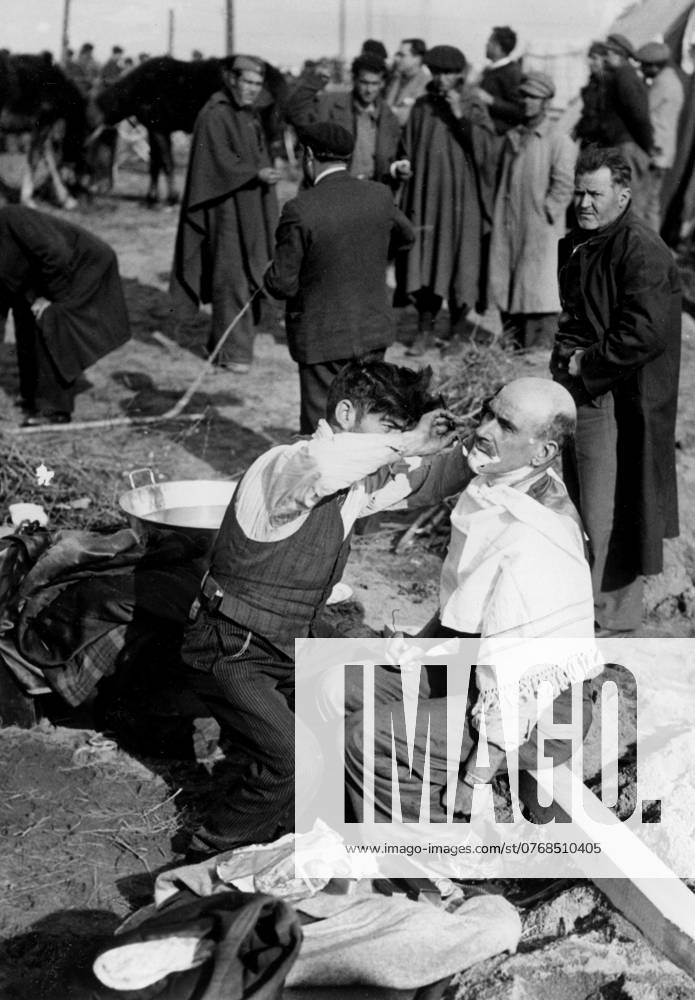 Orig caption THE SPANISH REUGIES AT THE FRONTIER OF THE PYRENEES The militia who are united at the concentration camp of Argeles organize little by little their existence Here is a militiaman who improvised as a hairdresser, and who shaves one of his comrades Note Spanish Civil War armed conflict between right wing and left wing forces in Spain 1936