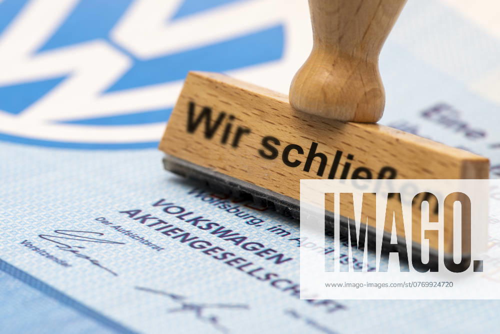 VW crisis with risk of plant closure A wooden stamp is labeled with the words We are closing, above a VW share with logo Symbolic image
