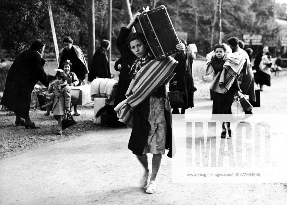 Orig. caption... FRANCE OPENS HER FRONTIERS TO REFUGEES. There were pitiful scenes at the French frontiers town of Le Pertros, when some of the thousands of refugees from Barcelona and districts began to be admitted by the authorities. The picture shows young and old, men & women, carrying their household goods the last few steps to the frontier which will take them to peace and freedom. Note Spanish Civil War - armed conflict between right-wing and left-wing forces in Spain 1936-39. The war began with a revolt against the incumbent Popular Front government. The right-wing forces (rebels), the Falange, with its leader General Franco, were supported by Italy and Germany. The government was supported by the left and volunteers from abroad in