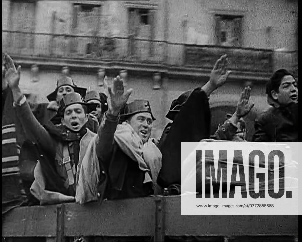 Spanish Fighters on the Back of a Lorry Making Fascist Salutes and Celebrating the Victory of Nationalist Fighters Taking Madrid With Most of Them Wearing a Celebratory Tricornio of the Spanish Civil Guard, 1939. From Time To Remember - The Reluctant Warriors, 1939 (Reel 1); documentary about events of 1939 - preparations for war and then hostilities break out.
