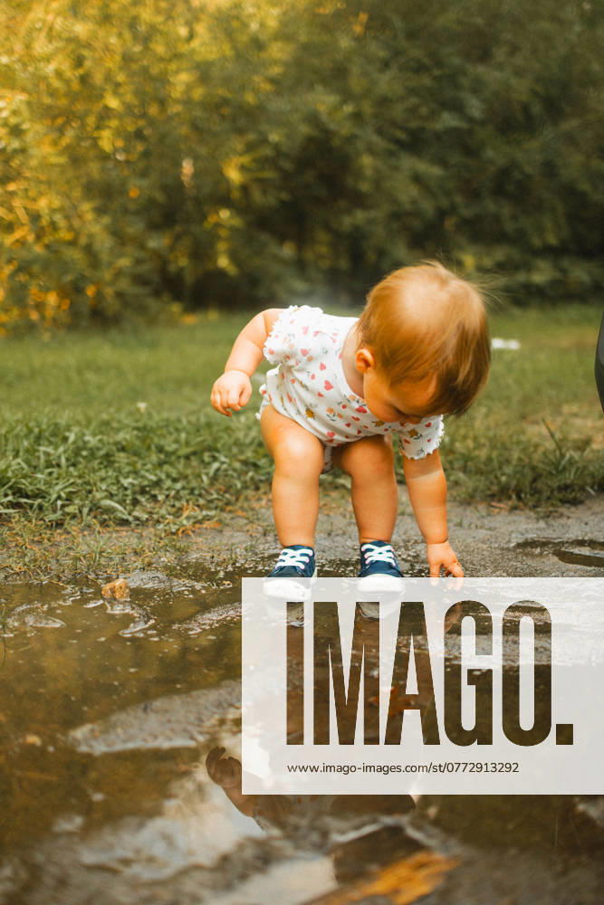 Toddler putting hands and feet in mud puddle Raleigh, North Carolina, United States R_XMBF241014-1562486-01 ,model released, Symbolfoto