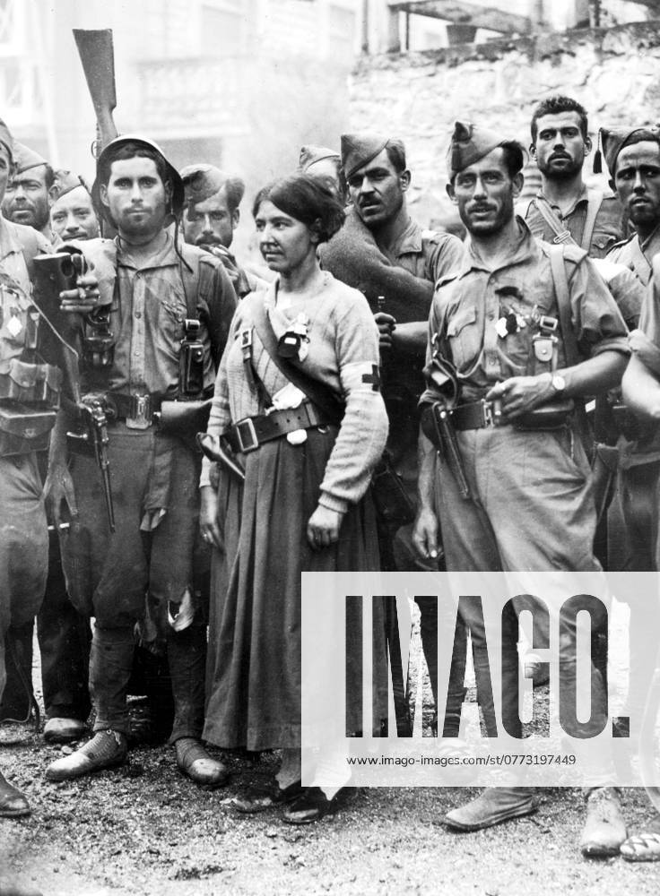 Orig. caption... IRUN FALLS TO THE NATIONAL REBELS. Irun is now a blackened and charred city, but the National Rebel troops are now in possession. They went round the city in sorties on a mopping up expedition as there is still some sniping going on from the few remaining Reds who are entrenched in famhouses etc. O.P.S. Members of the Spanish Foreign Legion (National Rebeltroops) photographed having a smoke when they entered IRUN. With them is the only Red Cross nurse who entered the city. Note the pistol she wears in her belt. Note Spanish Civil War - armed conflict between right-wing and left-wing forces in Spain 1936-39. The war began with a revolt against the incumbent Popular Front government. The right-wing forces (rebels), the Falang