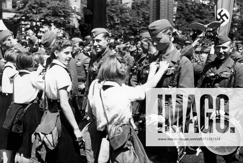 Orig caption DIE DEUTSCHE CONDORLEGION IN HAMBURG JUBELND EMPFANGEN On the march through the streets of the old Hanseatic city, the German fighters from Spain were repeatedly showered with endless cheers BdM girls pinning flowers to th