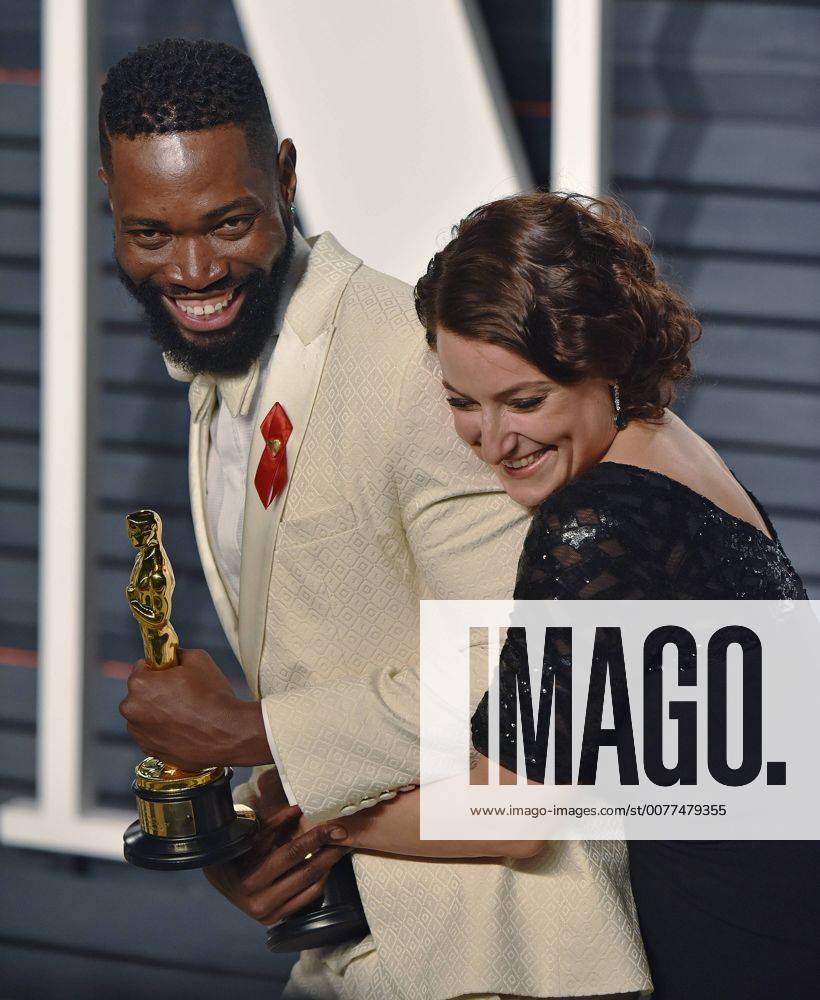 Writer Tarell Alvin McCraney (L) and producer Adele Romanski celebrate their Oscar wins for Moonlight as they arrive for the Vanity Fair Oscar Party at the Wallis Annenberg Center for the Performing Arts in Beverly Hills, California on February 26, 2017. LAP201702262103 CHRISTINExCHEW