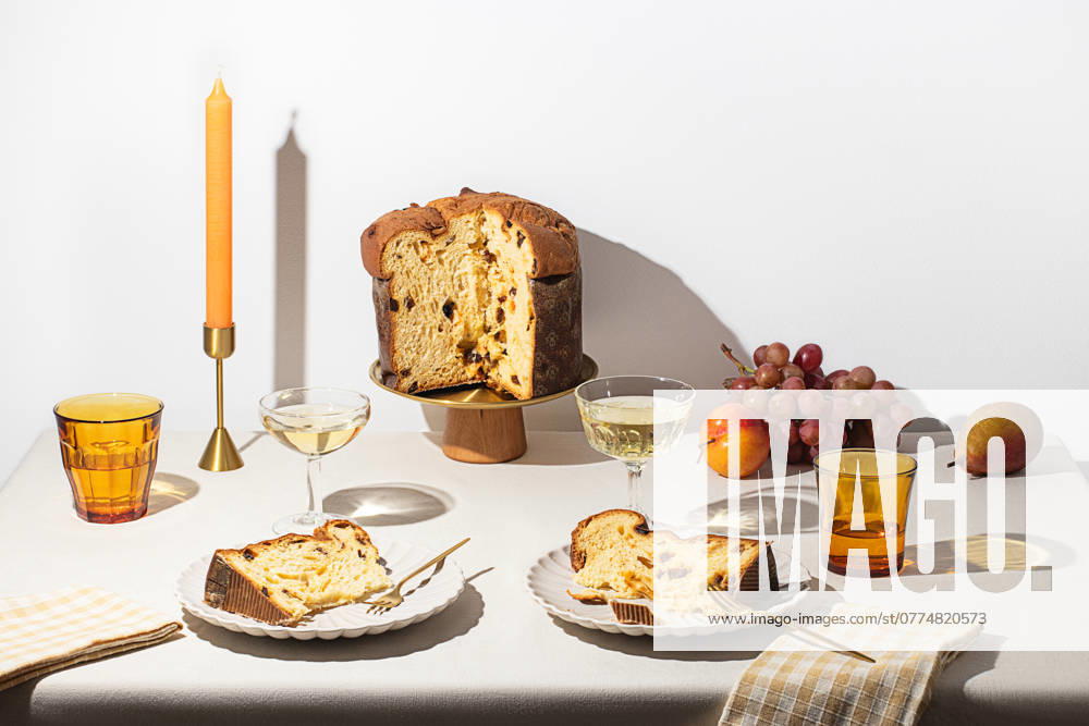 Beautifully arranged dessert table with Panettone, grapes, and sparkling wine, capturing the essence of Xmas holiday feasts Model Released OlgaVila_ID24397_707340_001