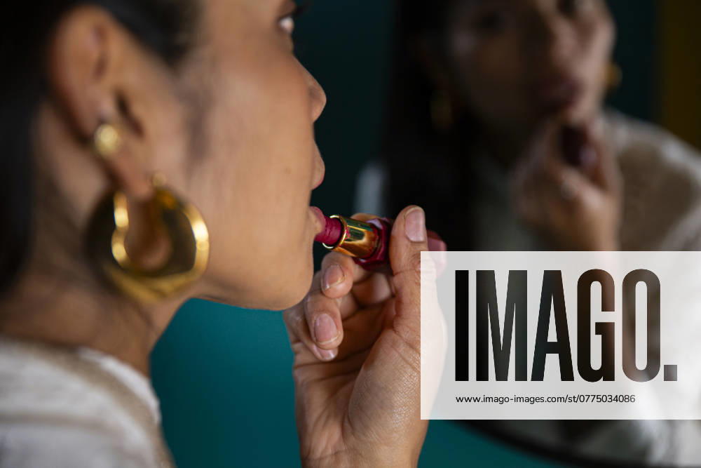 Woman applying lipstick in front of mirror model released, Symbolfoto property released, PCLF01431