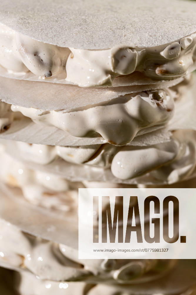 A detailed close-up view of layered traditional Christmas sweets, featuring slices of white nougat Turron de Alicante. Model Released AlexSalcedo_ID24574_712225_011