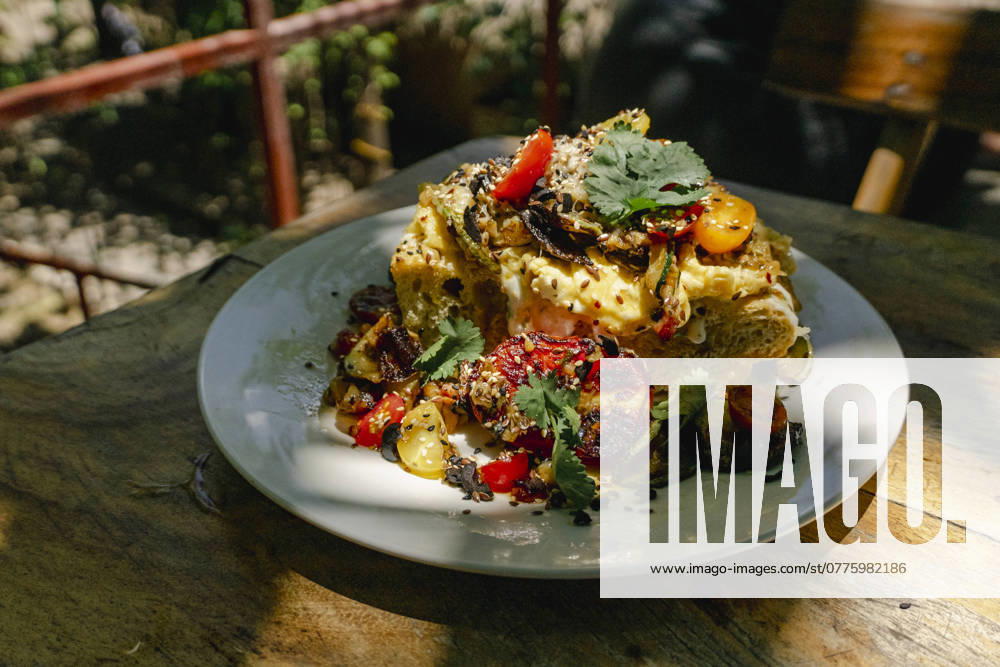 A beautifully plated Salvadoran dish, topped with fresh herbs and garnished with grilled vegetables, captures the essence of Central American cuisine. Model Released Almuzambrana_ID24112_698301_024
