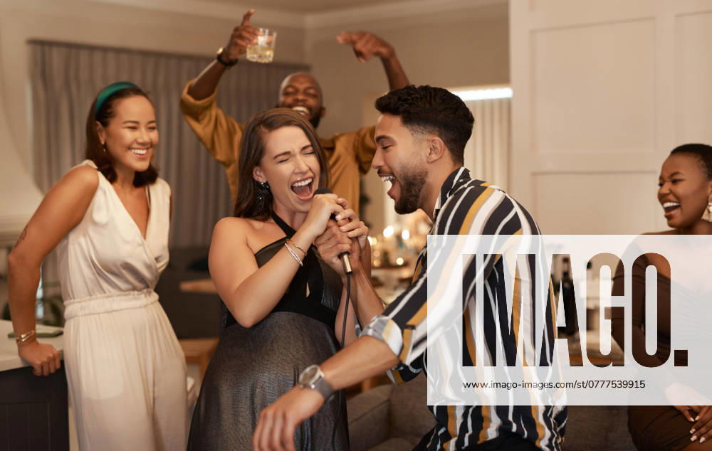 Friends, party and karaoke night at the house for fun social event or gathering together in celebration for new year. Happy people celebrating friendship, birthday or festive season singing at home. model released property released