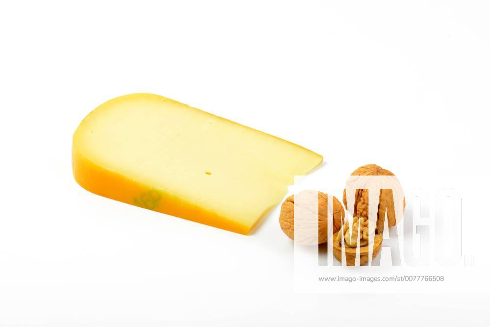Slice of gouda cheese with walnuts on white background CTKPhotoF201703101042301
