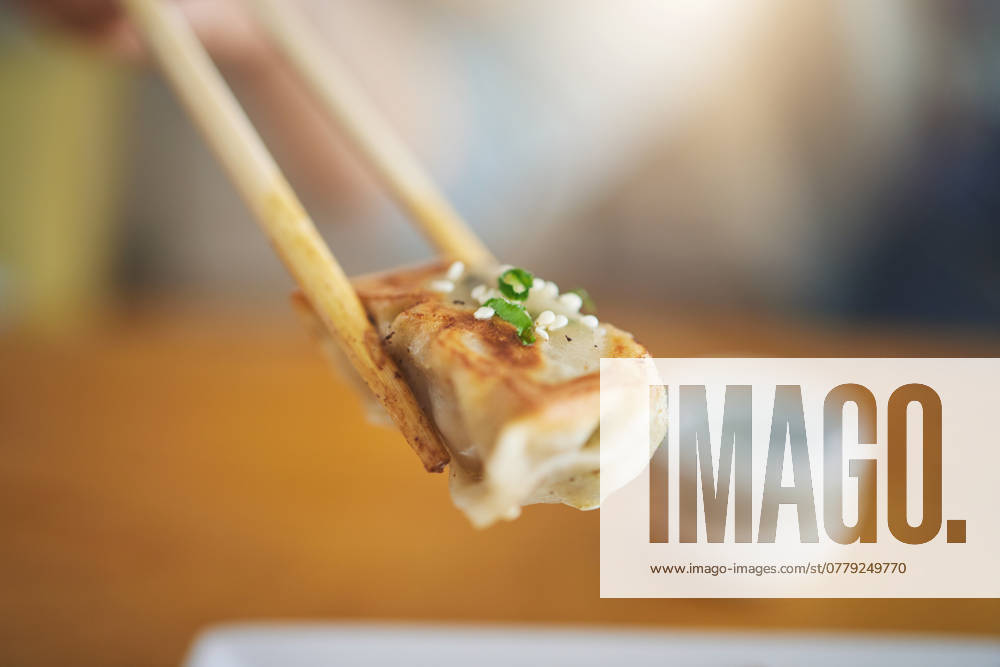IMAGO Creative, Food, Dumplings Closeup, protein and chopsticks with dumpling at a restaurant for food, Asian culture or fine dining. Health, hungry and person with dinner, eating lunch or enjoying a fried dish or cuisine at a cafe. model released property released