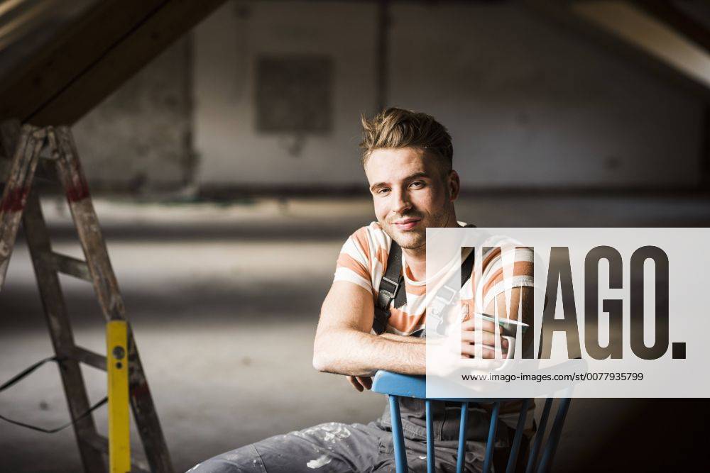 Young man sitting on construction site of his new home model released Symbolfoto property released UUF10141