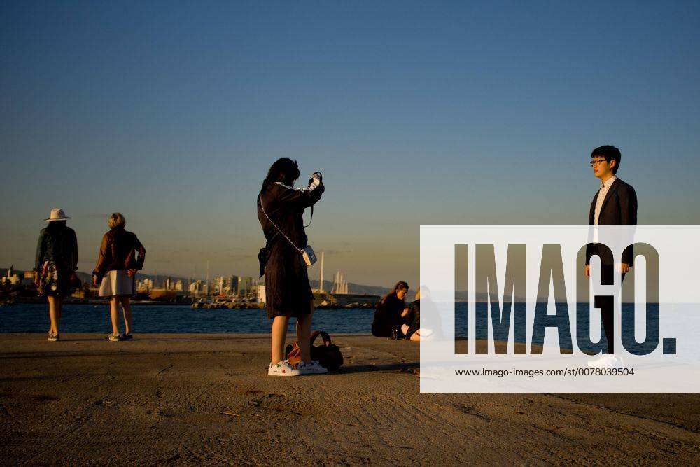 Barcelona, Catalonia, Spain - In Barcelona people, most of them tourists, stand at the corner of a breakwater as the sun sets on this 3rd April, 2017. Barcelona Spain - ZUMAn230 20170403_zaa_n230_130