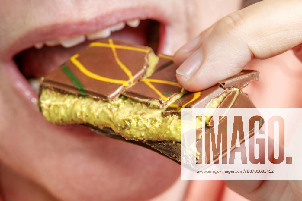 Woman enjoys a piece of Dubai chocolate with kunafa and pistachio cream filling, Hype about Dubai chocolate, Munich, November 2024 Germany, Munich, November 2024, Woman enjoys a piece of Dubai chocolate with kunafa and pistachio cream filling, Orient Delight brand, Made in U A E , United Arab Emirates, which includes Dubai, Hyp