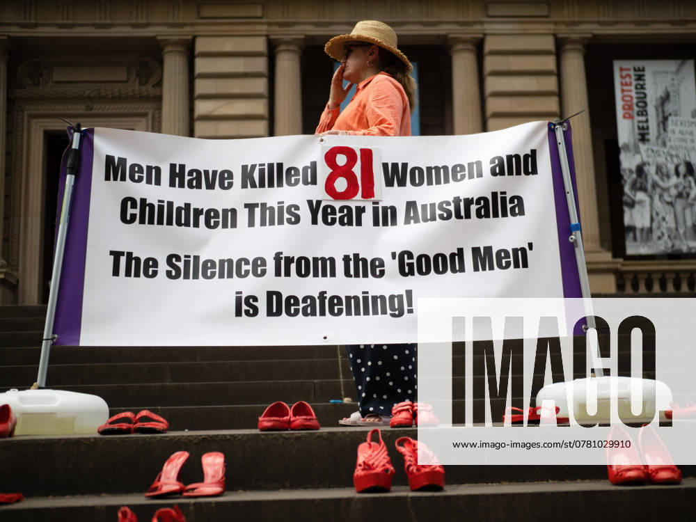 An organiser is seen behind a banner showing an already outdated figure of 81 women and children murdered, usually by men they knew knew, this year. 85 pairs of red shoes were placed on the steps of Treasury Place in honour and memory of these victims. In the immediate wake of three murders of young women from Melbourne, and eighty-five murders of women in Australia in 2024, an estimated 3,000+ people marched though the city centre calling for an end to domestic abuse and femicide. Most donned orange clothes; the colour of the anti-family-violence organisation, Respect Victoria, who organised the event. Melbourne Australia - ZUMAs197 20241122_aaa_s197_039