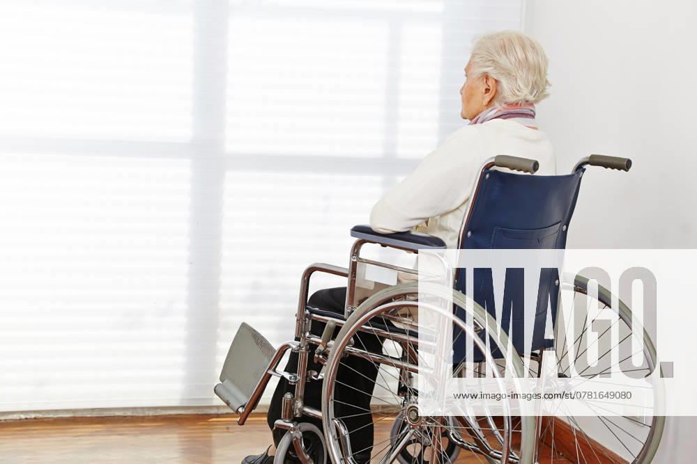 Einsame Seniorin im Rollstuhl schaut aus dem Fenster im Pflegeheim ,model released, Symbolfoto ,property released