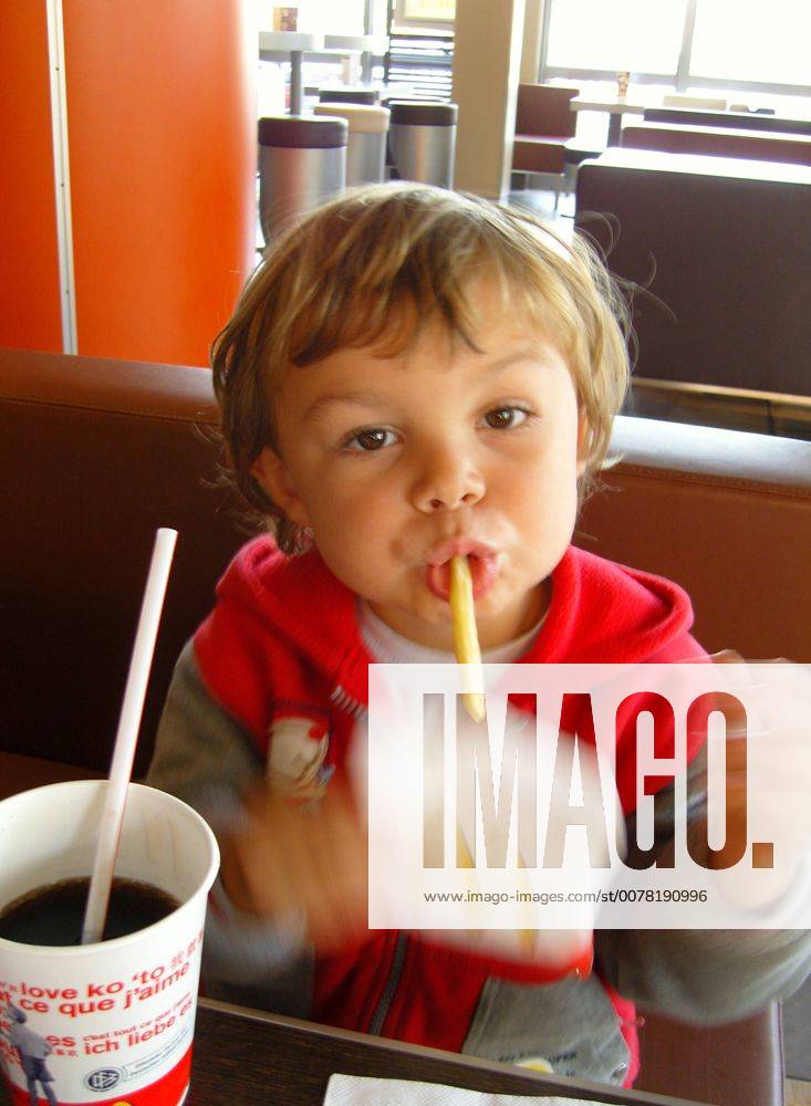 Ein kleiner Junge isst Pommes Frites bei Mc Donald s, Model-Release, 2006