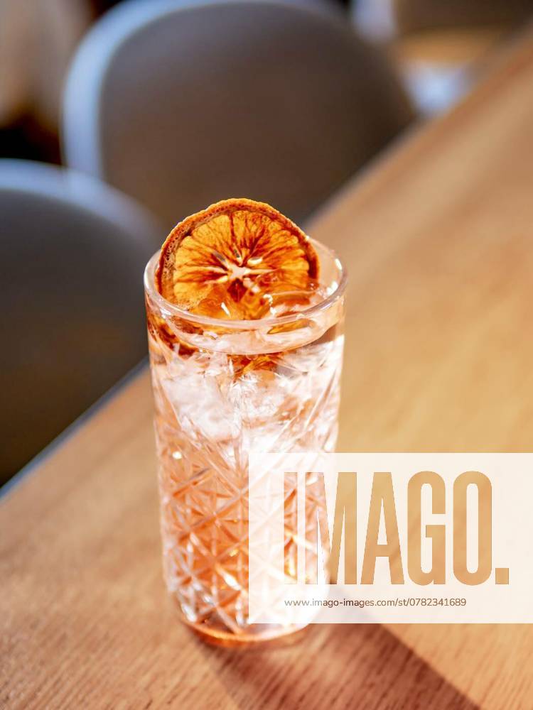 Transparent pink alcohol cocktail, vodka gin-tonic, Transparent pink alcohol cocktail with ice, vodka and gin-tonic on bar counter in restaurant interior. Alcohol cocktail decorated orange slice. Cold alcoholic cocktail in bar or nightclub. Copy space, Transparent pink alcohol cocktail with ice, vodka and gin-tonic on bar counter in restaurant interior. Alcohol cocktail decorated orange slice. Cold alcoholic cocktail in bar or nightclub. Copy space, 11.09.2024, AI generated