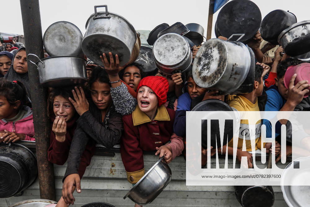 Palestinians crowd to receive food cooked by a charity kitchen amid shortages of food supplies in the southern Gaza Strip, in Khan Yunis in southern Gaza, on Friday on November 29, 2024. Palestinians, including children, who escaped from the attacks of the Israeli army and took shelter in Khan Yunis, wait in line to receive meals distributed by charities while Israel s attacks continue in Gaza. GAZ2024112920 Anas Deeb
