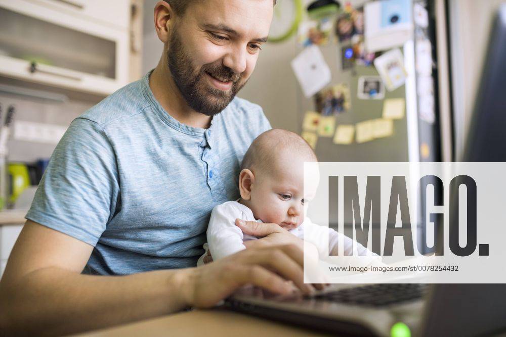 IMAGO Creative: 2022 Aussichten Father with baby son using laptop at home model released Symbolfoto property released HAPF01436
