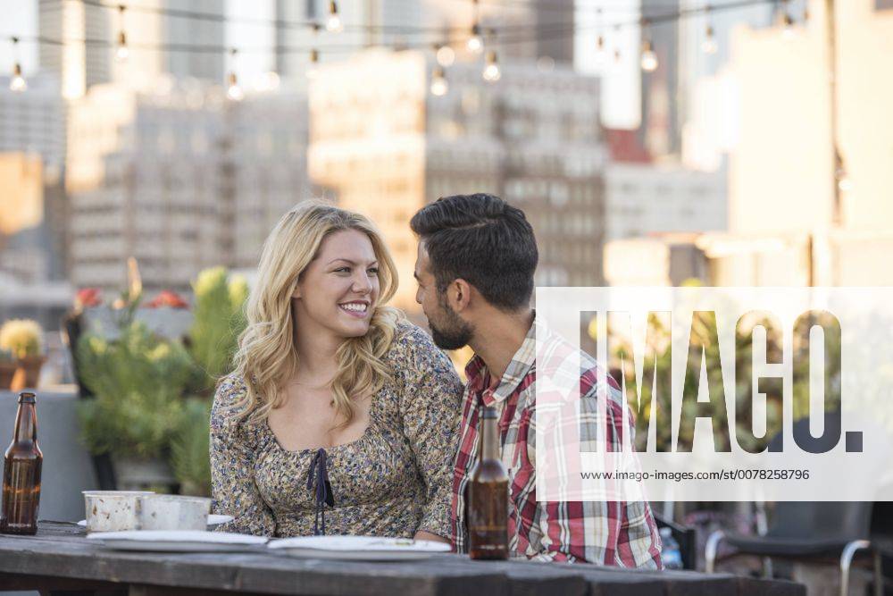 Friends having a rooftop party, couple flirting model released Symbolfoto property released WESTF22889